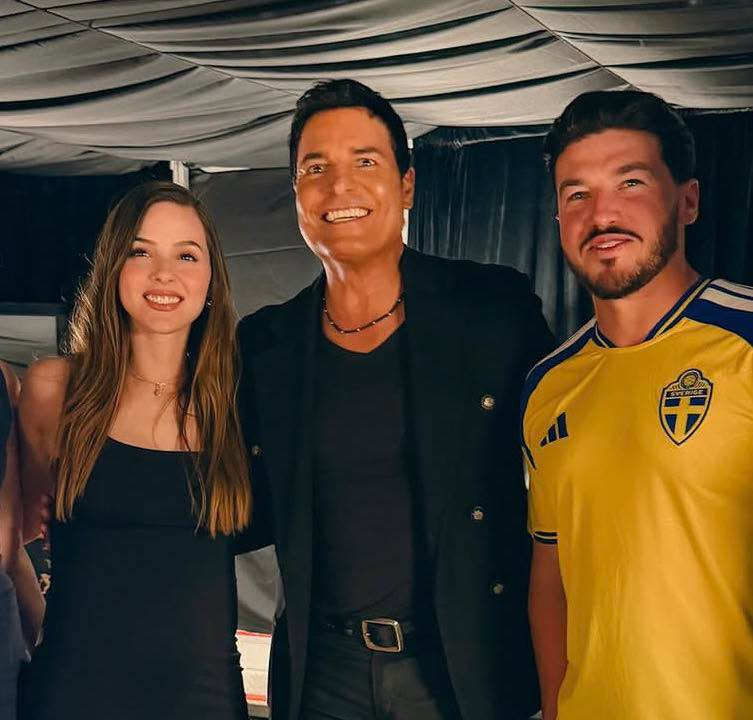 Image - Regios En México Three People Smiling at the Camera in a Backstage Area, Dressed in Smart Casual Outfits (woman in Black Dress, Two Men in Dark Clothing). - Regios En México