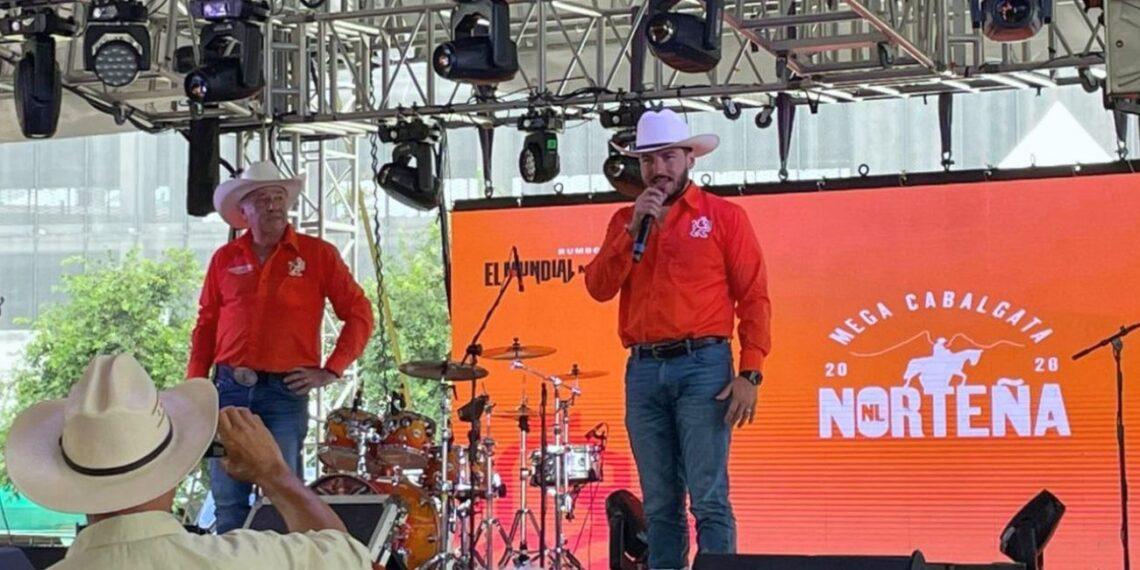 Two Men in Orange Shirts and White Cowboy Hats Sing on Stage with a Drum Kit; Orange Backdrop Reads 'norteÑa' and 'mega Cabalgata'. - Regios En México