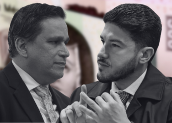 Two Businessmen in Suits Converse Closely, with a Blurred Money Backdrop Behind Them. - Regios En México