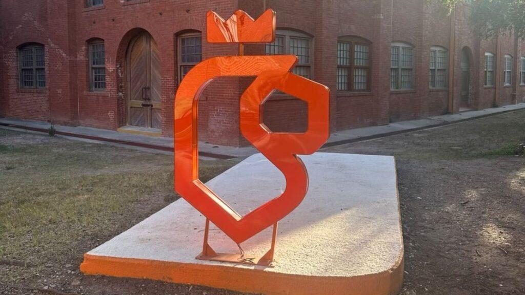 Totem-fosfo-de-samuel-garcia - Regios En México Bright Orange Abstract Metal Sculpture on a Concrete Pedestal in a Brick Courtyard. - Regios En México